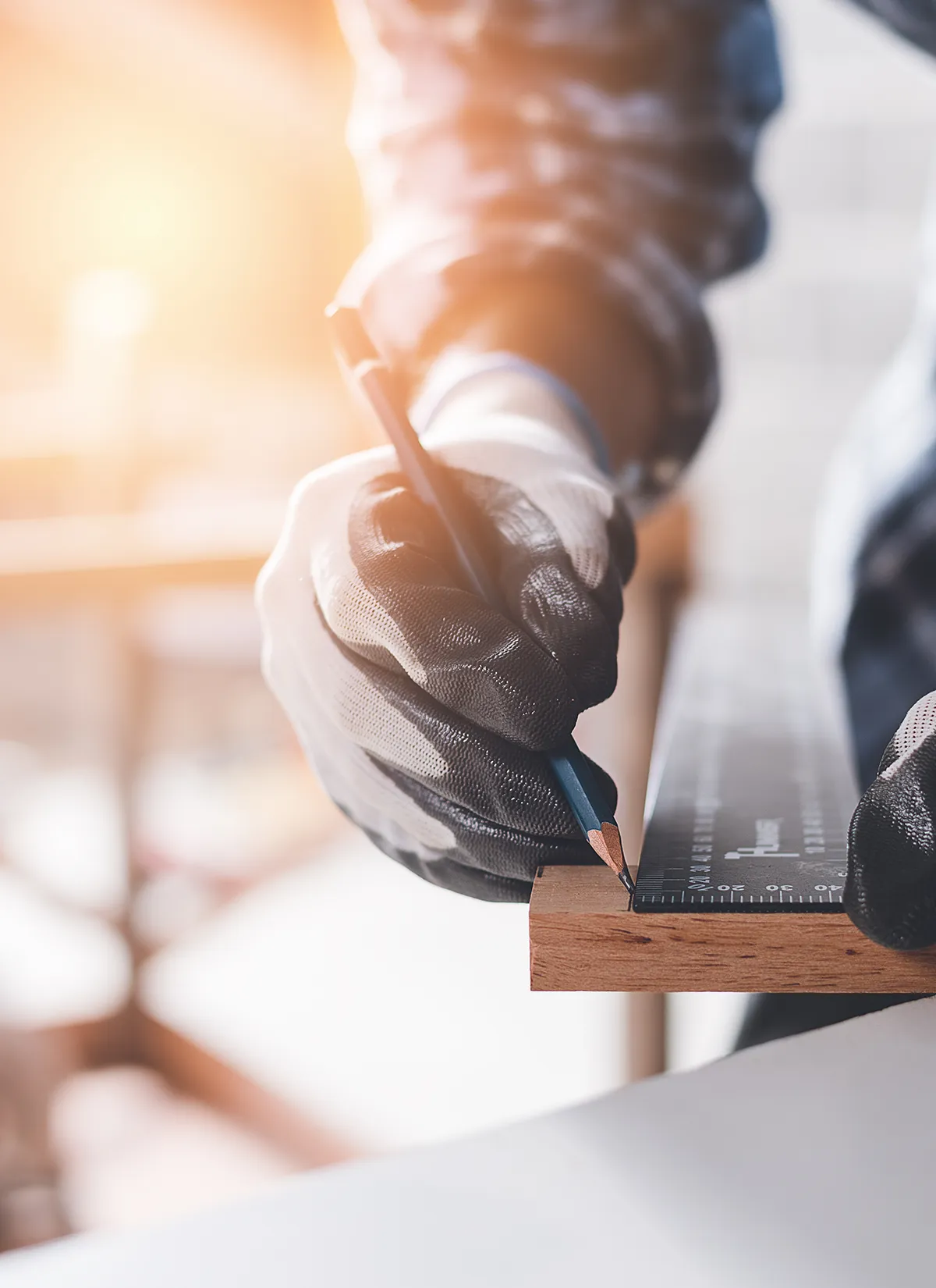 Selbstbewusster Holzarbeiter-Experte. Junger Mann arbeitet in einer Fabrik. Geschickter Tischler schneidet ein Stück Holz in seiner Holzwerkstatt.